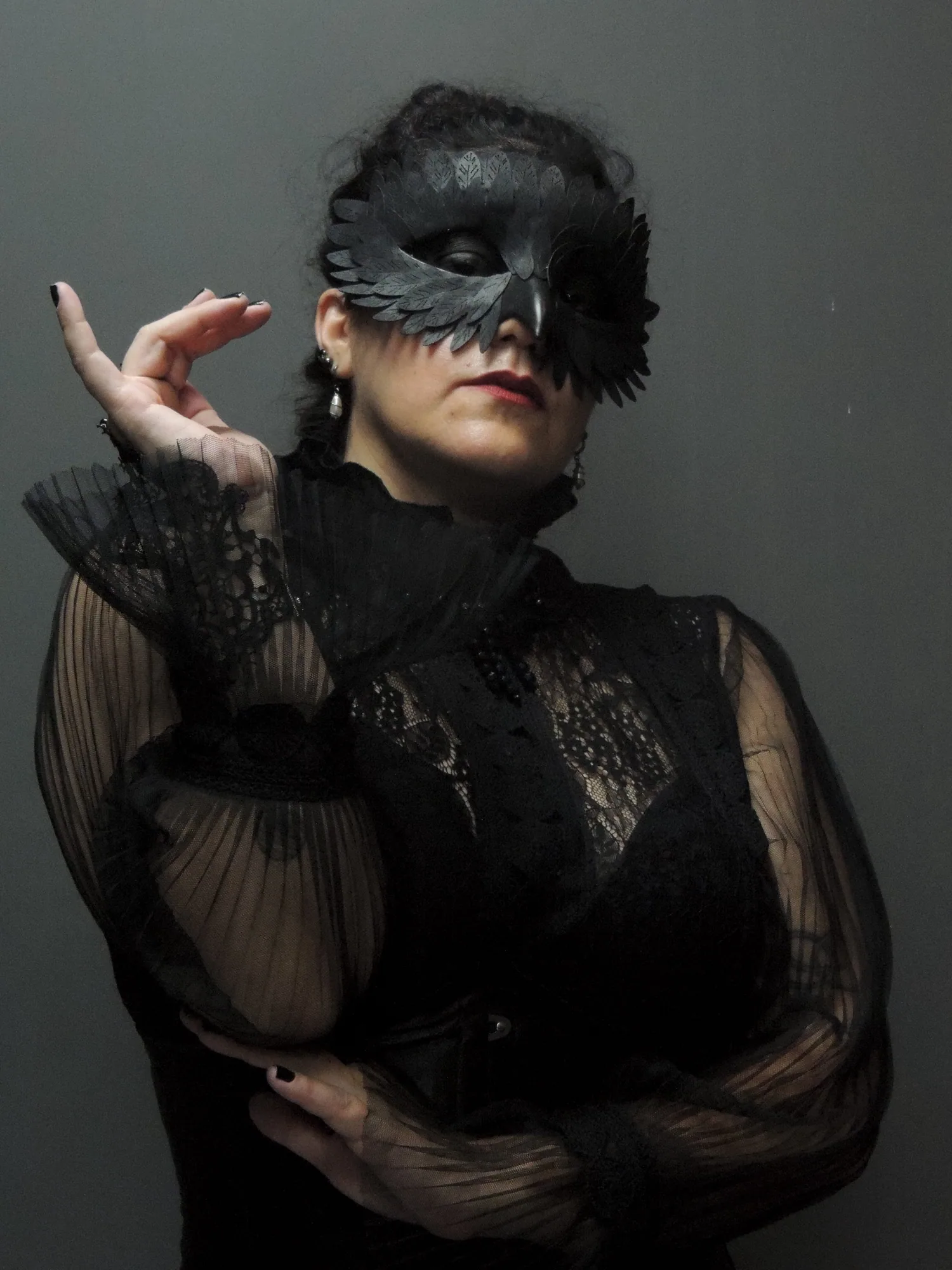The Countess usando máscara de corvo e traje rendado