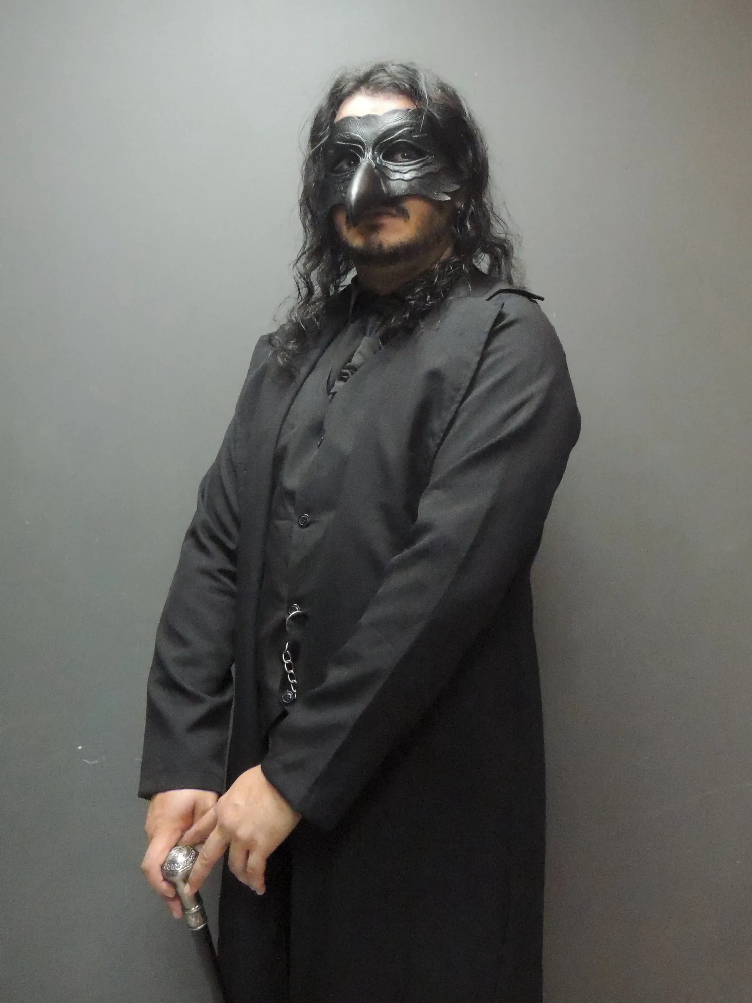 The Professor usando máscara de corvo, traje preto e bengala