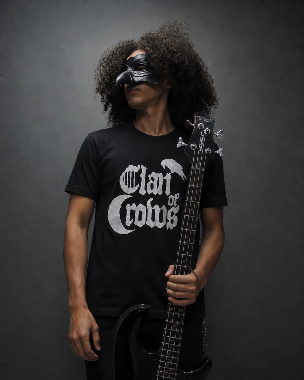 Integrante de Clan of Crows usando a camiseta oficial e segurando um baixo